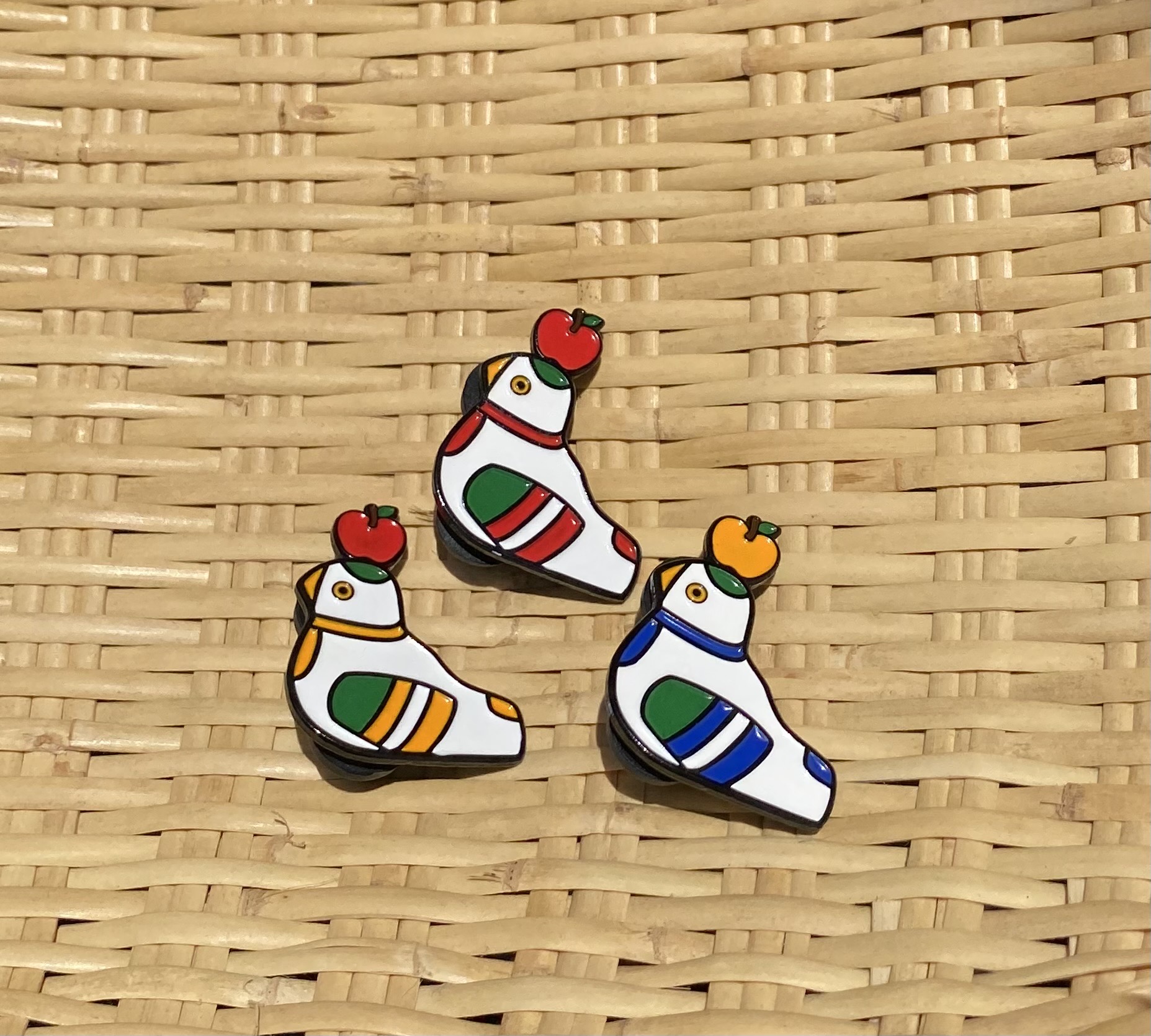 なんだか愛おしいこの鳩笛×りんごのピンバッチが再入荷しました